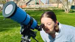 iOptron 80mm white light solar telescope being used by a female observer