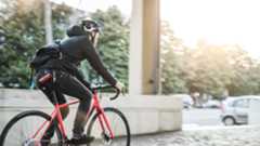 Bike messenger riding into a low sun, with a bike lock tucked away in his jeans pocket 