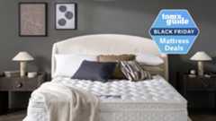 Premier Inn mattress in a brightly lit hotel room with a pillows and a blanket on the bed and a TG Black Friday mattress deals badge on the right side