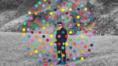 a black-and-white photo of a man in a field with colorful dots overlaid