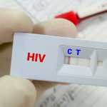 Rapid screening test for HIV (human immunodeficiency virus) screening test. Technician hold rapid test cassette,