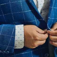 closeup of man buttoning suit jacket