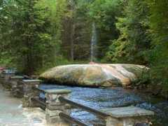 geyser island spouter shooting into the sky from an island of hardened minerals