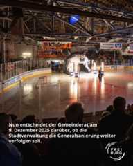 Dieser Alternativtext wurde KI-generiert: Eine Eisfläche mit Zuschauern im Hintergrund ist im Inneren eines großen Gebäudes zu sehen. Im Vordergrund ist ein Teil einer Zuschauertribüne mit Personen erkennbar.