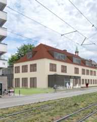 Dieser Alternativtext wurde KI-generiert: Ein Gebäude mit einem roten Satteldach steht neben einer Straßenbahnstrecke. Bäume und Fußgänger sind ebenfalls im Bild zu sehen.