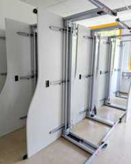 Dieser Alternativtext wurde KI-generiert: Mehrere mobile Trennwände stehen nebeneinander. Die Wände sind weiß und an silberfarbenen Schienen befestigt.