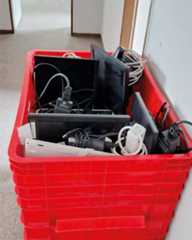 Dieser Alternativtext wurde KI-generiert: Ein roter Plastikkasten ist mit verschiedenen elektronischen Geräten und Kabeln gefüllt. Das Bild ist farbig und zeigt eine Ansammlung von Technik in einem Behälter.