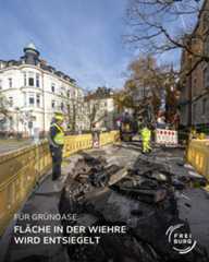 Dieser Alternativtext wurde KI-generiert: Eine Straßenszene zeigt Bauarbeiten, bei denen der Straßenbelag entfernt wird. Im Hintergrund ist ein Gebäude und Bäume zu sehen.