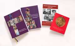 Dieser Alternativtext wurde KI-generiert: Mehrere Bücher unterschiedlicher Farbe liegen auf einer weißen Oberfläche. Die Buchcover zeigen historische Fotografien und Illustrationen.