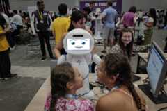 Des enfants interagissent avec un robot lors de la conférence ’AI for Good’ à Palexpo, Genève, le 8 juillet 2025.