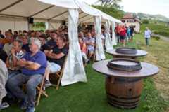 Rencontre de vignerons romands au domaine de la Vissenche, Gilly, sous une tente avec des tonneaux en avant-plan, le 21 juillet 2025.