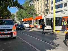 Des personnes attendent un tram ou un bus le long des rails à Genève, lors de la grève du personnel des Transports publics genevois, le 12 octobre 2022.