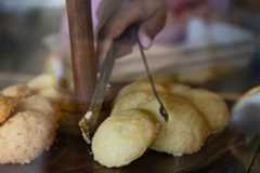 A baker sets out lemon cookies in a display.