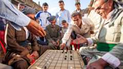 Kurdish men play dama, a game similar to checkers, in Erbil. (Photo: International Mission Board)