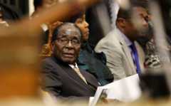 FILE PHOTO: File photo of Zimbabwe's President Mugabe listening as FM Chinamasa presents the country's 2014 National Budget to Parliament in Harare