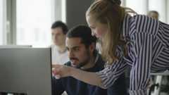 Teacher helping student in a computer lab