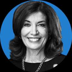 Headshot of New York Governor Kathy Hochul on a blue background.