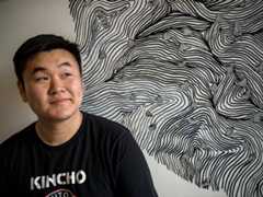 Student smiles in front of their art