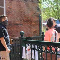 man in mask greets patrons