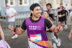 A man in a SCHF bib running in an event