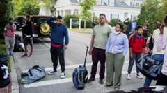 Immigrants gather with their belongings outside St. Andrews Episcopal Church