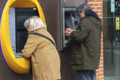 Dos personas operando en cajero automático de una entidad en Madrid.