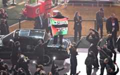 El hombre con la bandera subido a un coche que formaba parte del show.