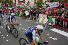 Los ciclistas del equipo Israel Premier Tech compiten mientras personas que portan banderas palestinas intentan interrumpir la undécima etapa de la carrera ciclista de la lt;HIT gt;Vuelta lt;/HIT gt; a lt;HIT gt;España, lt;/HIT gt; de Bilbao a Bilbao, lt;HIT gt;España lt;/HIT gt;, el miércoles 3 de septiembre de 2025. (AP Photo/Miguel Oses)
