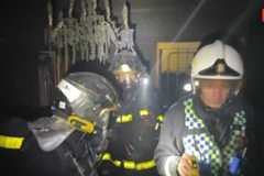 Los bomberos trabajan en el interior de la vivienda donde se ha producido el incendio.