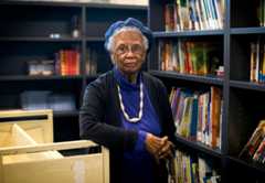 An older woman looking directly at the camera in a library.