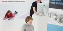 People writing and looking at laptop during a workshop