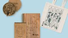 tote bag with line art of leaves, wooden covered notepads, and a wooden ornament with an owl