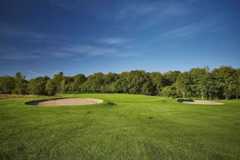 A view of a green flanked by bunkers at Alresford Golf Club.