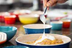 Especial Cozinha / Guia para cozinhar em casa. Chef Mauricio Lopes, mistura iogurte natural ao frango durante preparo de prato   na escola Wilma Kovesi de cozinha