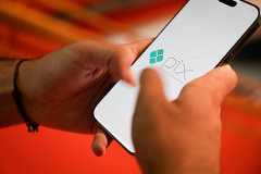 Cliente manuseia celular com logotipo do Pix