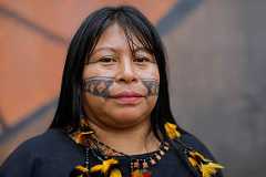 Indigenous leader Alessandra Munduruku poses in front of the mural 
