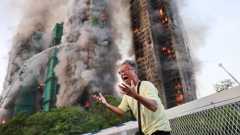 A man reacts, as smoke rises while flames engulf bamboo scaffolding across multiple buildings at Wang Fuk Court housing estate, in Tai Po, Hong Kong, China, November 26, 2025. REUTERS/Tyrone Siu ORG XMIT: LIVE