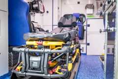 Innenraum eines Rettungswagens mit Fahrtrage, Patientenmonitor und Schränken mit Rettungsmaterialien