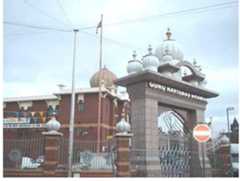 Figure 11: Guru Ravidass Bhawan, Handsworth, Birminghan  In Birmingham, too, a debate took place between Buddhists who “advocated naming the new place  TET DUTT TIAL, (UU, A USNMALS LUUIN VIALS VMOELWCC!! DUUUITTOLO WII GAUVUUALSU TIGIIIYy Ie TOV Iau  after Ambedkar, [and Ravidassis, but] they were outnumbered and the building was duly named Gi Ravidass Bhawan.”“%A broadly similar process took place across Britain’s other SC communities. Temples in Bedford, Derby, Coventry, Leicester, and Southall have similar stories behind them. In Bedford, for instance, at first there was just one gurdwara which served all Punjabis. The arrival of Kenyan Sikhs resulted in a separate Ramgarhia Gurdwara, and in 1972, a Ravidassi Mandir was  purchased, followed by a separate Balmiki Mandir. Separate Buddhist and Punjabi Christian  Acanriatione were aleon ectahliched 44 Thire currantly for a nonislatingn of fawer than 10 NNN Piiniah 