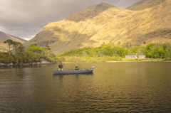 Anglers in boat on lake with mountain background