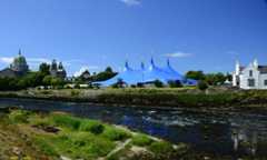 River with cathedral and concert tent in background