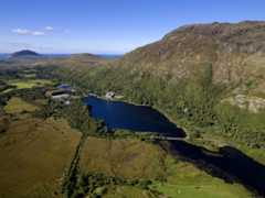 Aerial view of Kylemore Abbey and lakes with mountain in background