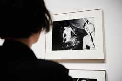 見世物小屋の光景を写した作品を観入る鳥居。