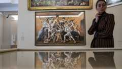 An exhibition staff member stands near artworks <i>Chariot Race</i> (<i>top</i>) and <i>The School of Gladiators: The Combat</i> by Italian painter Giorgio de Chirico at the press preview of the <i>Dans l'appartement de Léonce Rosenberg - De Chirico, Ernst, Léger, Picabia</i> exhibition at the Picasso Museum in Paris.