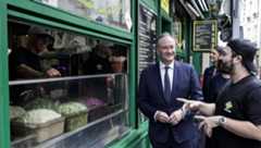 US second gentleman Doug Emhoff speaks with the employee of a restaurant at the site of a deadly 1982 antisemitic attack.