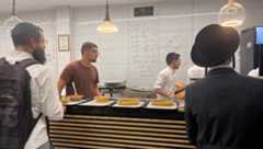 A diner buys cholent at Cholent on the Roof in Geula, Jerusalem, on July 10, 2025.