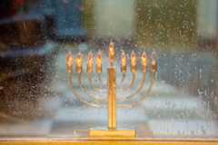 A Hanukkah menorah is displayed in a window on the seventh night of the holiday.