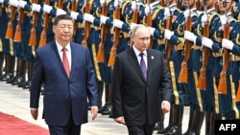 Vladimir Putin (right) and Chinese President Xi Jinping review a military honor guard at a ceremony in Beijing to welcome the Russian president on May 16, 2024.