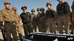 Armenia -- Servicemen stand near the coffin of Manvel Saribekyan, an Armenian taken captive by Azerbaijani forces, during his body's return to Azerbaijan on the Ijevan-Qazax highway near the village of Kayan, 04Nov2010