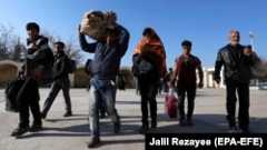 Afghan refugees cross the border into Afghanistan's Nimroz Province after they were deported by Iran. (file photo)